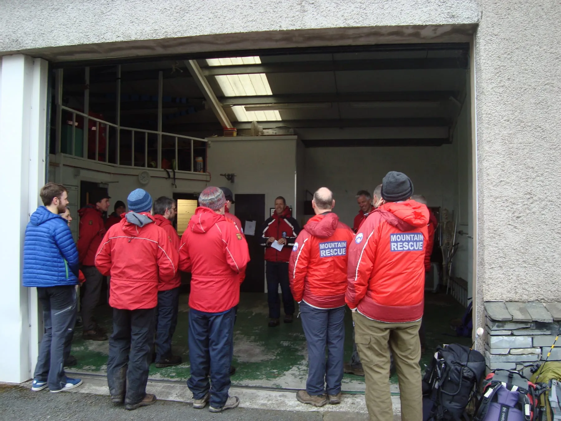 Team members in red jackets gathered at the open door of the current base