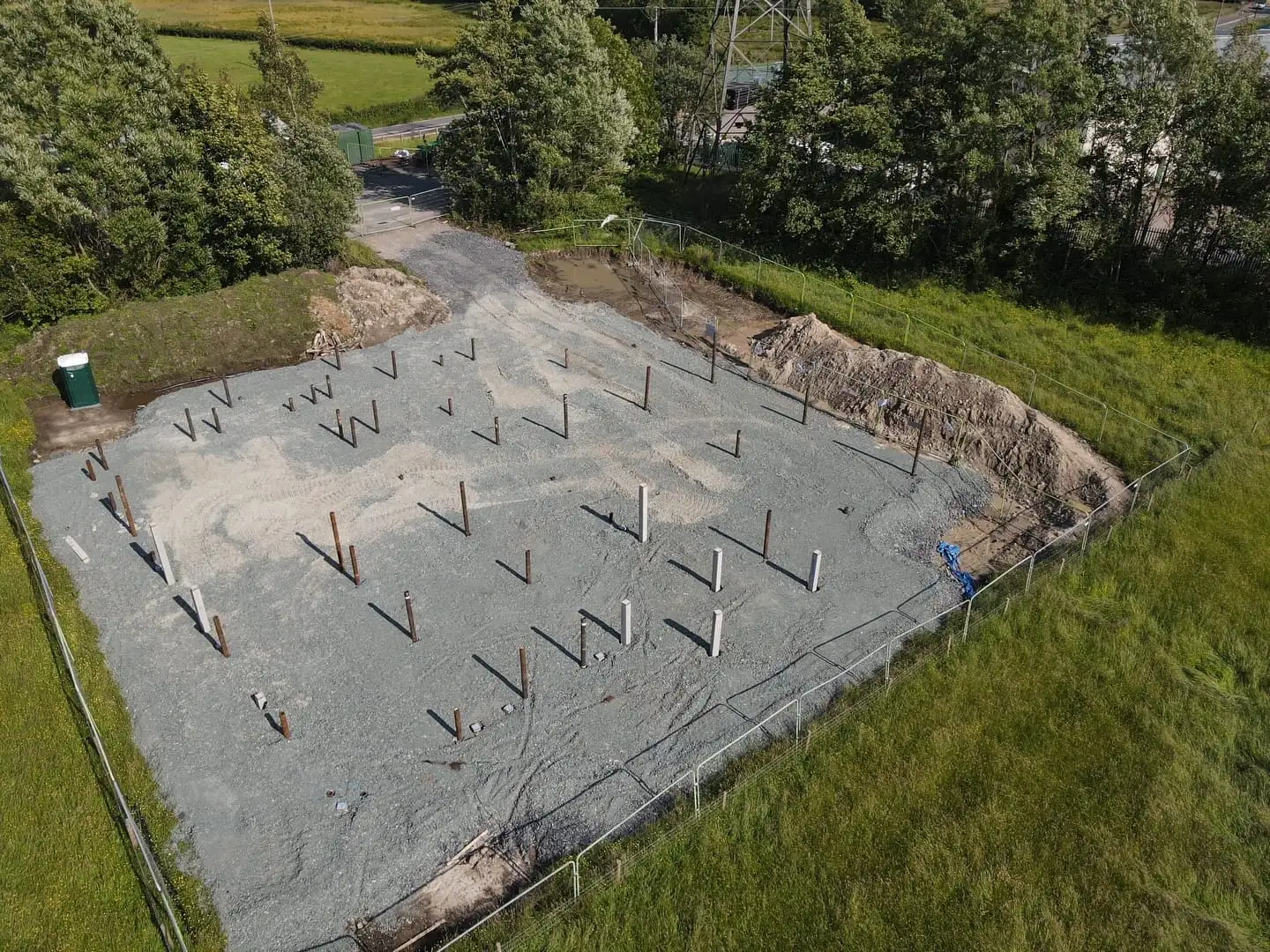 Piles set out across the gravel foundation of the new base