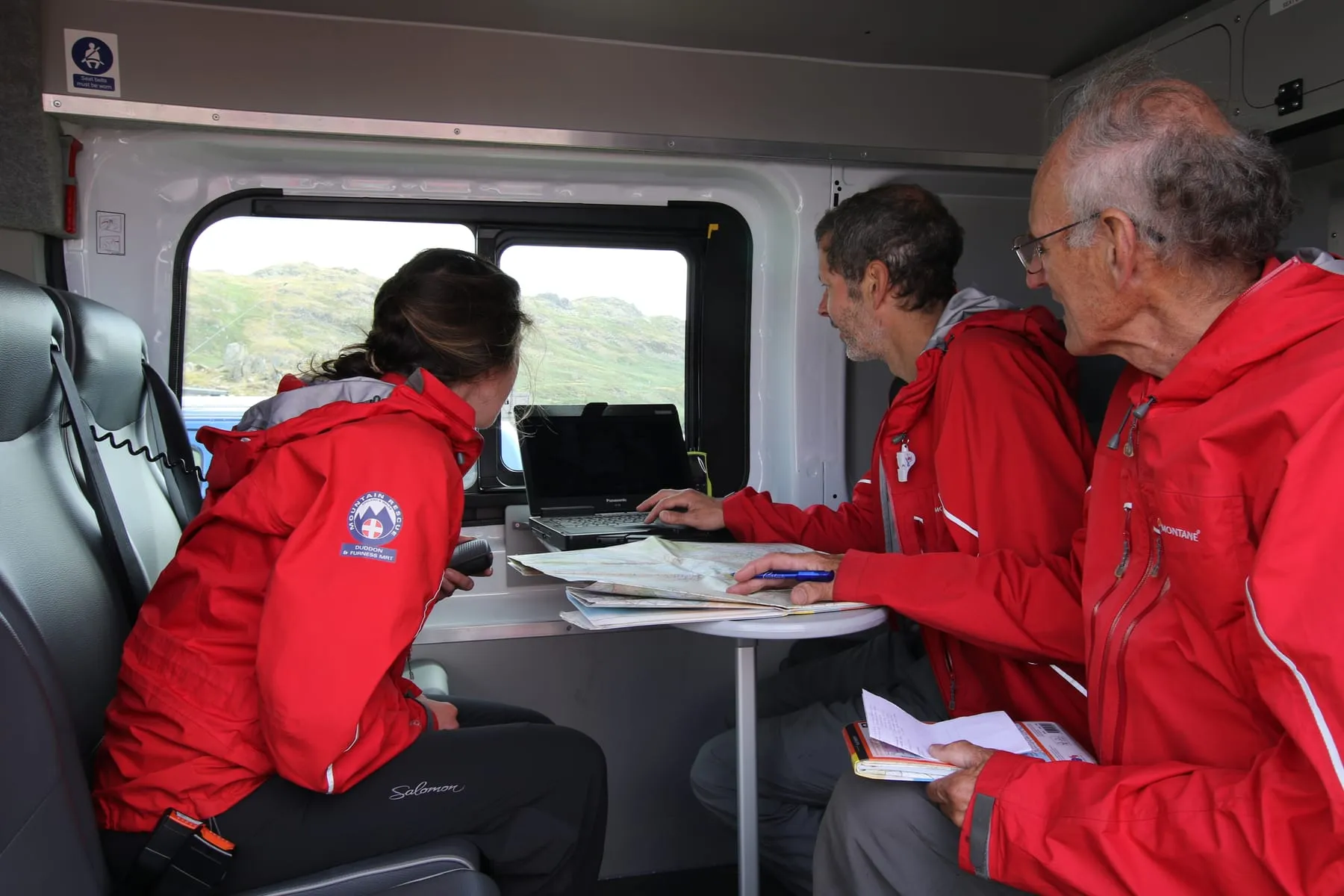 Team members at a laptop and map inside the Transit